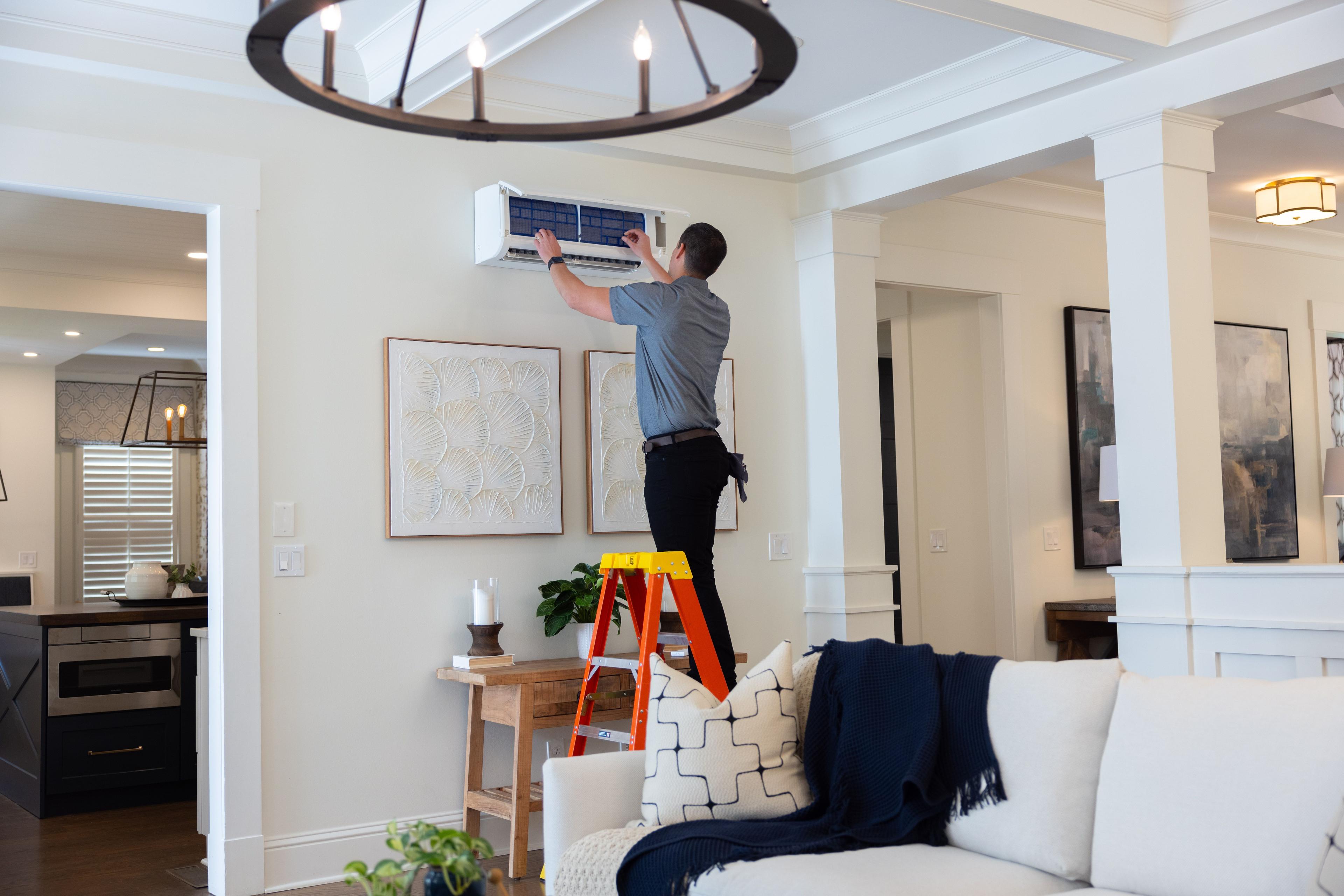 Technician servicing indoor wall-mounted unit