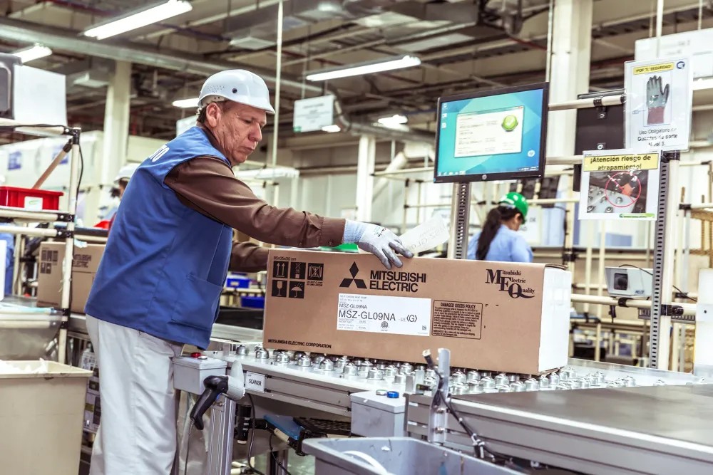 Factory worker packaging outbound Mitsubishi Electric product